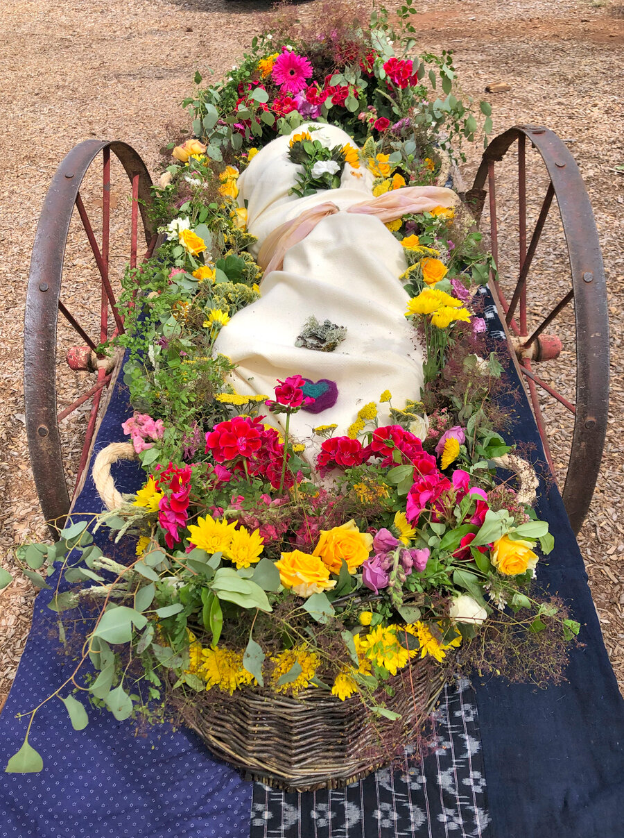A willow “soul boat” is adorned in flowers and rests on a hand cart before its burial at White Eagle Memorial Preserve near Goldendale, Washington.